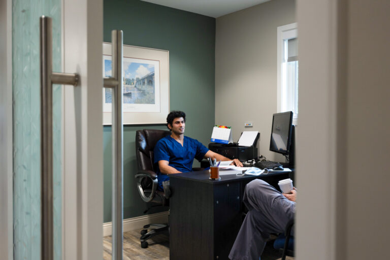 Dentist in a private consultation room speaking with a patient at Orchard Family Dental in Leduc